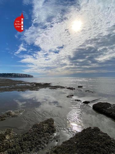 a kite flying in the sky over a body of water at Villa clair de Falaises in Le Tréport