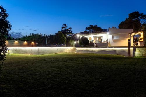 a house with a yard at night at Oceana - Exclusive Beachfront Villa with Private Pool and BBQ by GG in Alexandroupoli