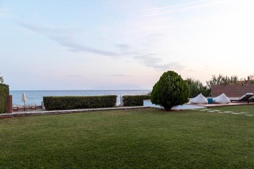 a lawn with a view of the ocean at Oceana - Exclusive Beachfront Villa with Private Pool and BBQ by GG in Alexandroupoli