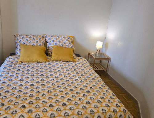 Cette chambre comprend un lit avec deux oreillers et une lampe. dans l'établissement ''Appartement spacieux, ultra central-Gare et centre 1 mn a pied'', à Muret