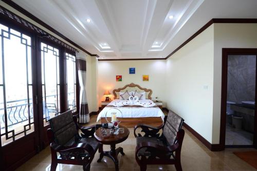 a bedroom with a bed and a table and chairs at Vientiane Luxury Hotel in Vientiane