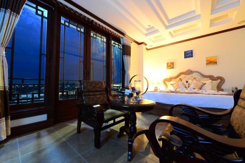 a bedroom with a bed and a table and chairs at Vientiane Luxury Hotel in Vientiane