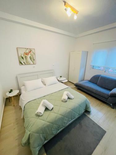 a bedroom with a bed and a blue couch at Studio 87 in Rhodes Town