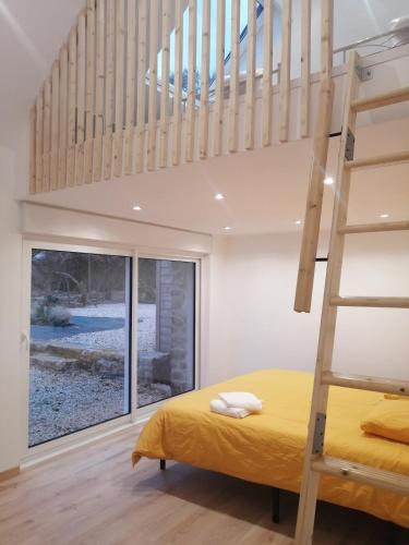 - une chambre avec un lit jaune et une échelle dans l'établissement Villa des Agapanthes, à La Terre du Pont