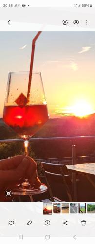 a glass of wine sitting on a table with the sunset at Gasthof goldener Engel in Kemnath