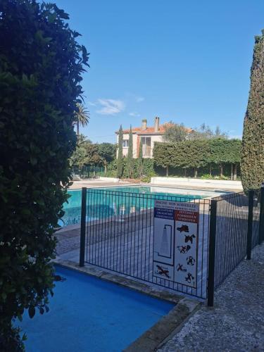 une clôture à côté d'une piscine avec un panneau à côté dans l'établissement Magnificent studio in Saint Tropez, à Saint-Tropez