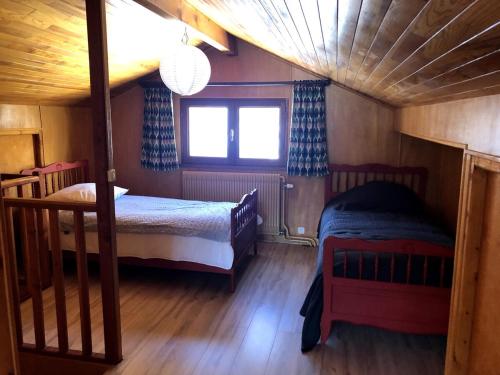 une chambre avec deux lits superposés et une fenêtre dans l'établissement Chalet Les Pommiers, à Vallouise