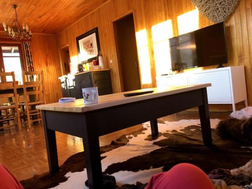 une table dans un salon avec une télévision dans l'établissement Chalet Les Pommiers, à Vallouise