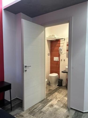 a bathroom with a door leading to a toilet at Rosso Relativo in Acilia
