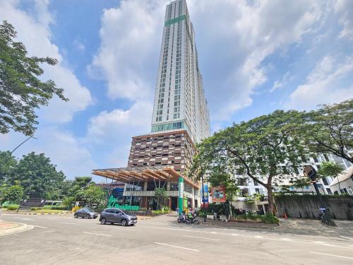 a tall building with a car parked next to a street at Apartemen B Residence By LiviRooms BSD CITY in Cilandak