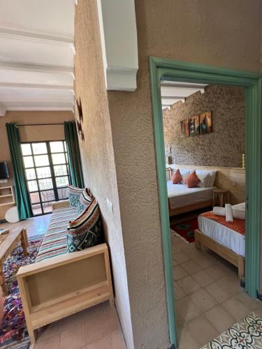 a room with a bedroom with a bed and a mirror at Tazart Lodge in Marrakech