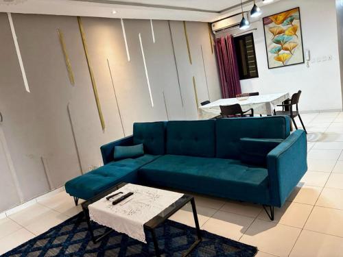 a living room with a blue couch and a table at Le spacieux-Salon XXL & 2 chambres in Cocody