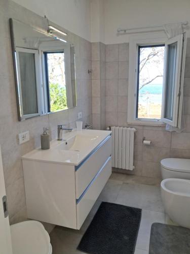 a bathroom with a sink and a toilet and a mirror at Residence LE DUNE in Ortona