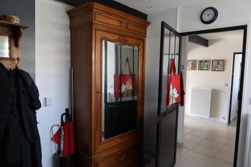 une grande armoire en bois dans un couloir avec une horloge dans l'établissement Petite Maison bord de mer, à Pornichet