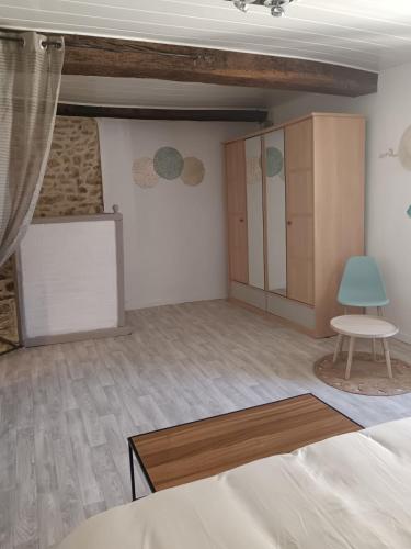 une chambre avec un lit, une table et une chaise dans l'établissement Maison au bord de l'eau, à Apremont