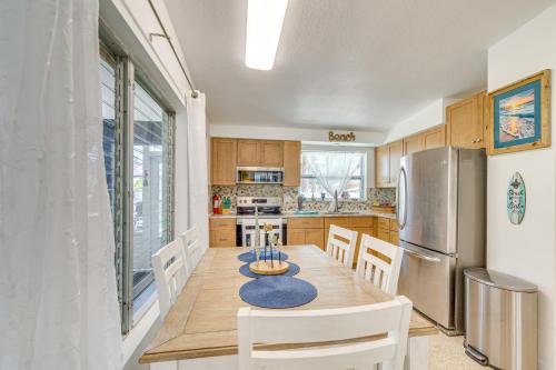 a kitchen with a wooden table and a refrigerator at Hot Tub and Gas Grill Port Richey Retreat in Port Richey