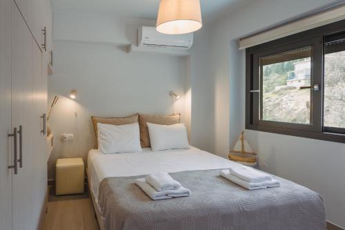 a bedroom with a bed with two towels on it at Amelia Luxury Suite in Nikiana
