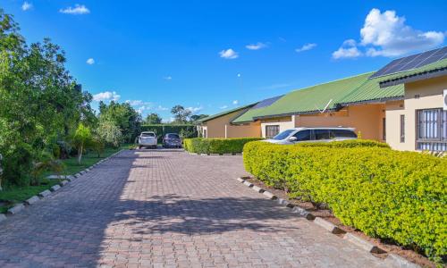 a brick road in front of a building with a car at Leopard Tree Apartments in Lusaka
