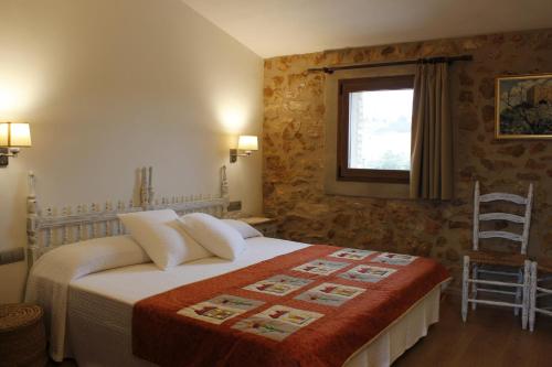 Campredó的住宿－Mas Dauden，一间卧室设有一张床、一个窗口和一把椅子