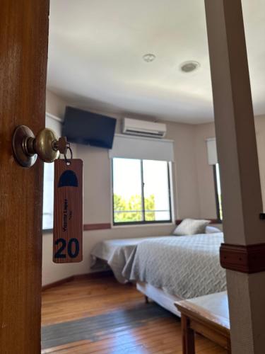 a bedroom with a bed and a sign on the door at Hotel Vicente López in Vicente López