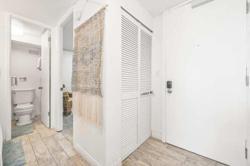 a bathroom with a toilet and a white door at Beautiful Condo Right on the Beach in Hauula