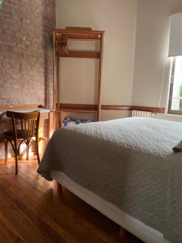 a bedroom with a bed and a table and a mirror at Hotel Vicente López in Vicente López
