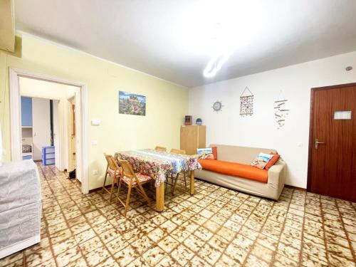 ein Wohnzimmer mit Sofa und Tisch in der Unterkunft Dimora Scacciapensieri a Marina di Cecina by Zoom In Earth in Marina di Cecina
