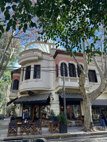 a building with tables and chairs in front of it at Hotel Vicente López in Vicente López