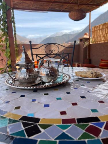 a table with plates of food on top of a mosaic floor at Tazart Lodge in Marrakech
