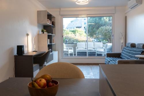 un salon avec un bol de fruits sur une table dans l'établissement Appartement avec terrasse à un pas de la plage, à La Rochelle