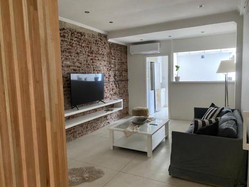 マル・デル・プラタにあるHouse Avellanedaのレンガの壁、テレビ付きのリビングルーム