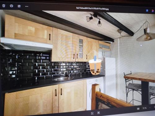 une cuisine avec un évier et une cuisinière four supérieur dans l'établissement maison atypique terrasse vue st victoire, à La Celle-sous-Gouzon