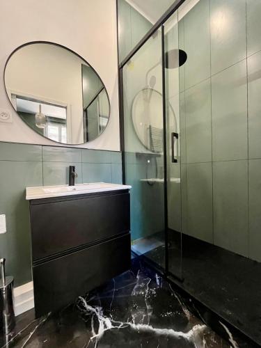 une salle de bain avec un lavabo et un miroir dans l'établissement La Violette, à Rouen