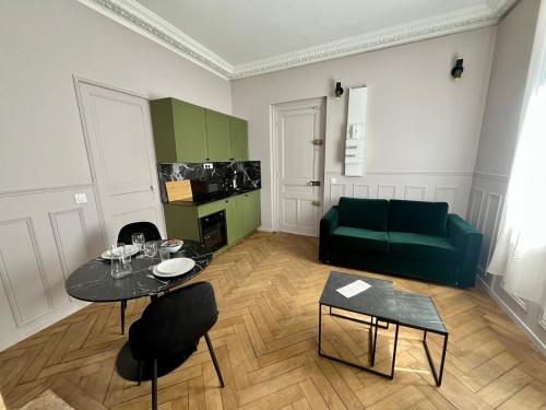- un salon avec une table et un canapé vert dans l'établissement La Violette, à Rouen