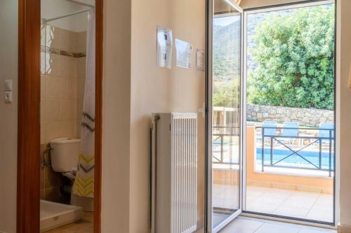a bathroom with a glass door leading to a balcony at Villa Nikolas in Balíon