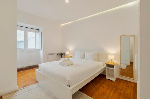 a white bedroom with a white bed and a window at Palmela Oásis Apartment I in Palmela