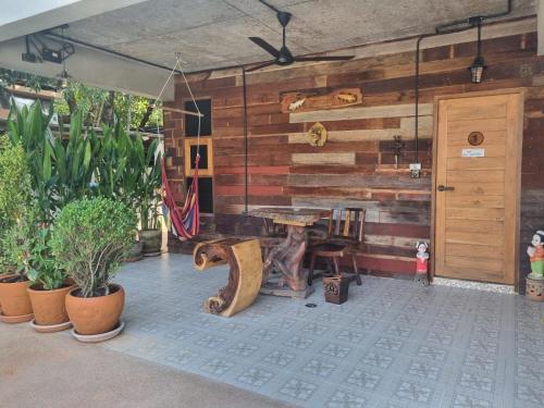 a patio with a wooden wall with a bench and plants at Chiang Ron in Chiang Mai