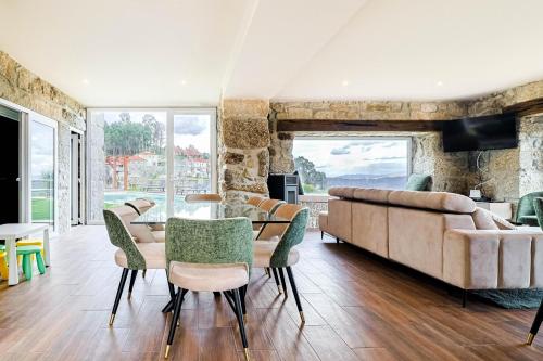 a living room with a table and chairs and a couch at Casa Vale do Luar in Celorico de Basto