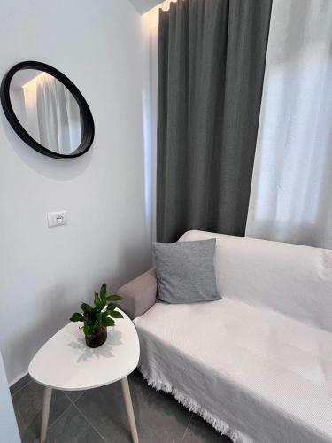 a living room with a white couch and a mirror at Villa Agur Kapo in Ksamil