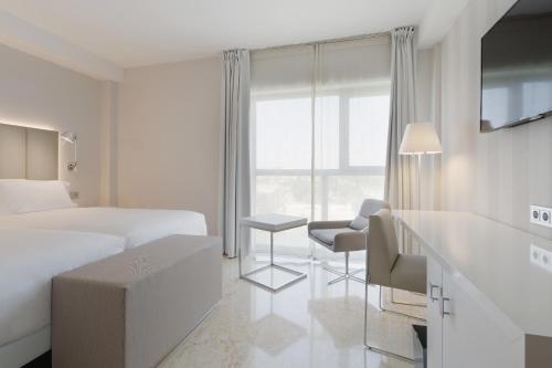 a hotel room with a bed and a desk at NH Ciudad de Zaragoza in Zaragoza