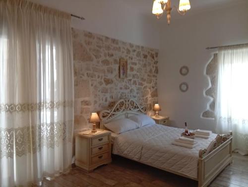 a bedroom with a bed and two lamps and a window at Tselekos House Old renovated stone house crete in Galiá