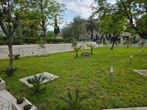 a yard with trees and a stone wall at Villa BOJANA AS Aparments Risan in Risan