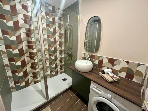 une salle de bain avec douche et machine à laver dans l'établissement Le Coquelicot, à Rouen