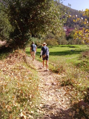 two men walking down a dirt path in a field at Tazart Lodge in Marrakech