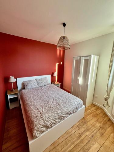 - une chambre avec des murs rouges et un lit blanc dans l'établissement Le Coquelicot, à Rouen