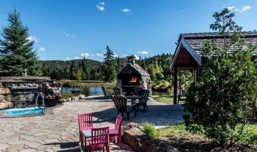 a patio with a table and chairs and a fireplace at Royal Laurentien in Mont-Blanc
