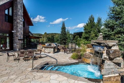 a stone patio with a water fountain in front of a building at Royal Laurentien in Mont-Blanc