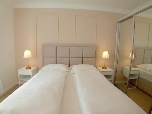 two beds in a bedroom with two lamps on tables at Apartments Angie in Zadar