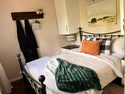 ein Schlafzimmer mit einem Bett mit einer grünen Decke darauf in der Unterkunft Griffin's Nest Cottage in Mbabane