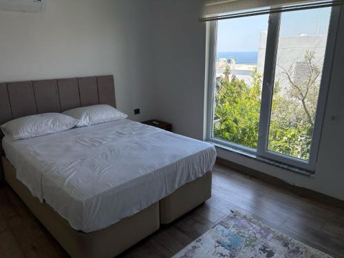 a bedroom with a bed and a large window at Villa the Moon in Dalaman